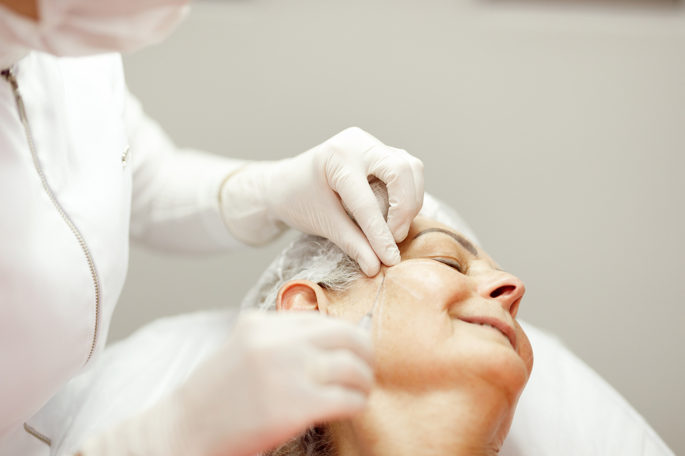 Woman smiling to help beautician apply biostimulants on her face